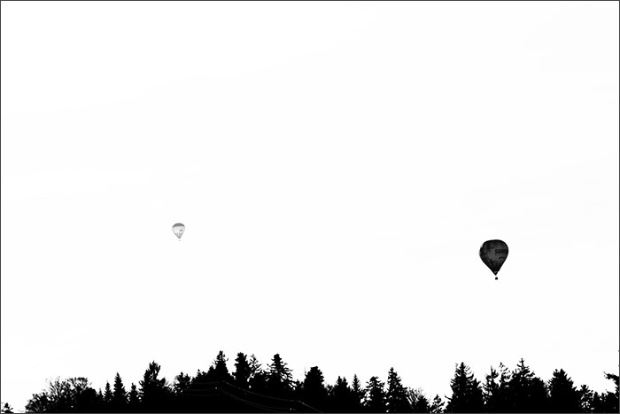 Luftballone am Himmel über Wald