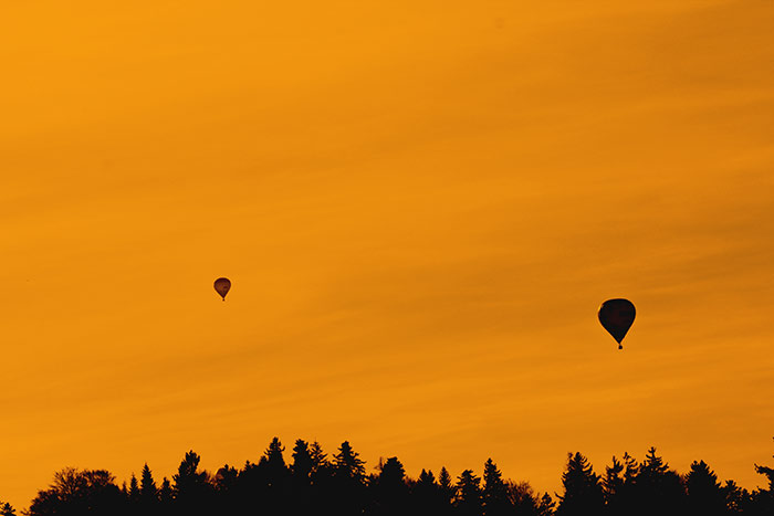 Heissluftballone im orangen Himmel