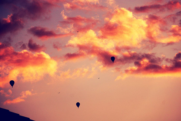 Heissluftballone am roten Abendhimmel mit Wolken