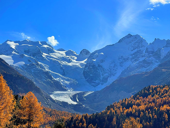 Naturfoto Landschaft mit Gletscherberg, blauem Himmel und herbstlichen Wäldern