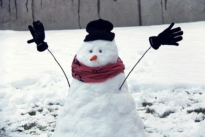 Schneemann mit Mütze, Halstuch, Handschuhen und Rübe im Gesicht