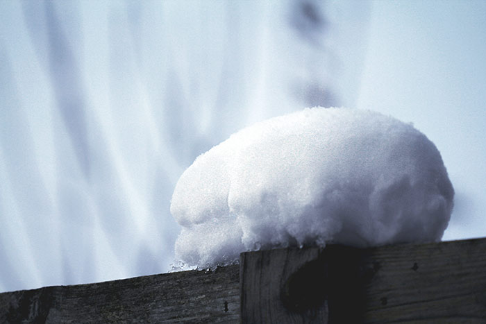Schneehügel auf Zaun